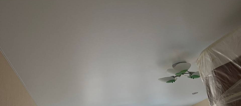 Matēti balti griesti ar stilīgu lustru viesistabā