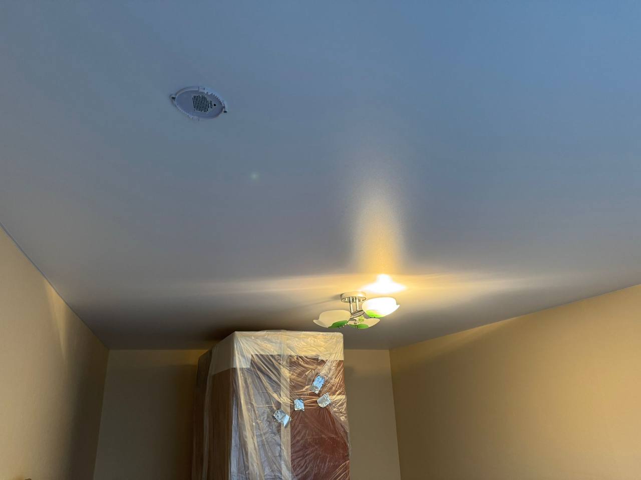 Matēti baltie griesti ar stilīgu lustru viesistabā